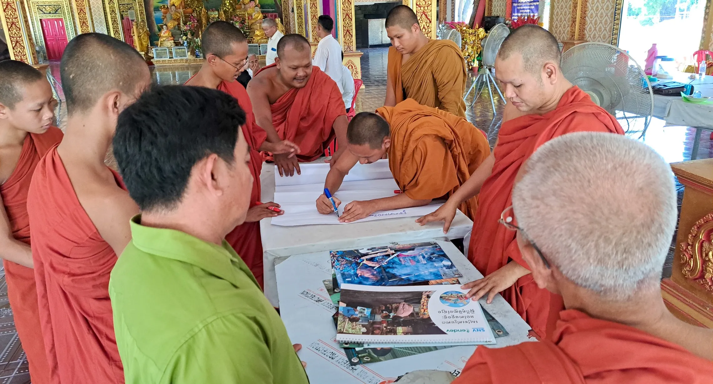 monks looking at smoke free manuals