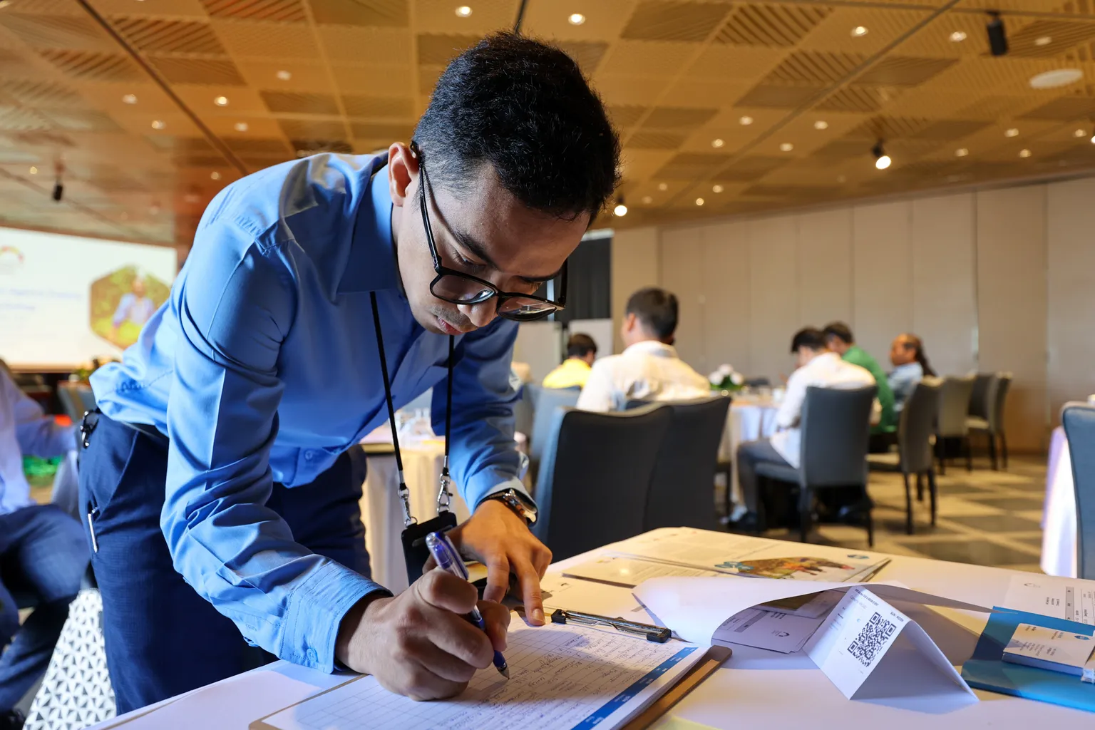 An SNV business advisor leans over a table, reviewing an application to the IAP fund