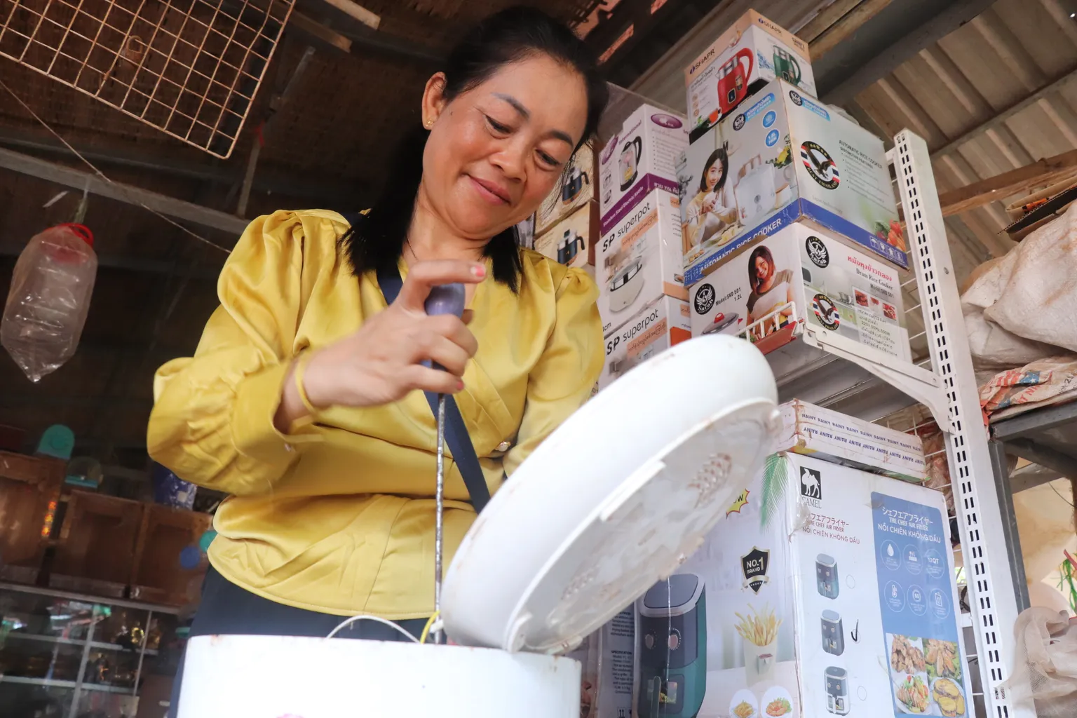 A woman repairing an electric cooker