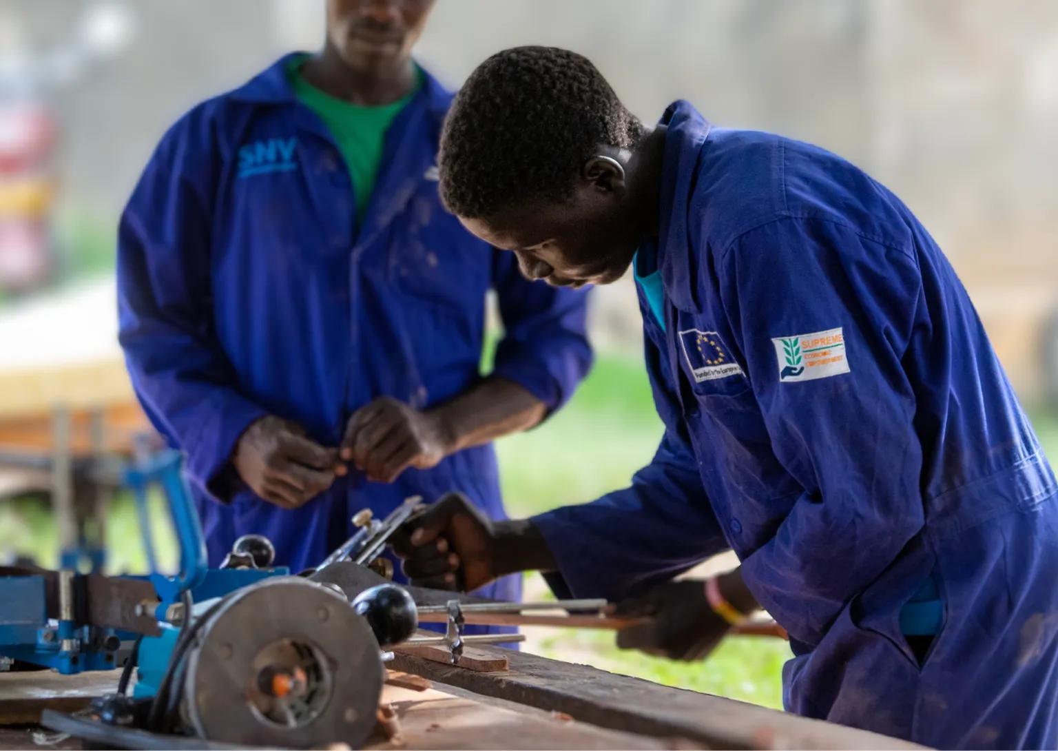 A young man working on a carpentry machine 